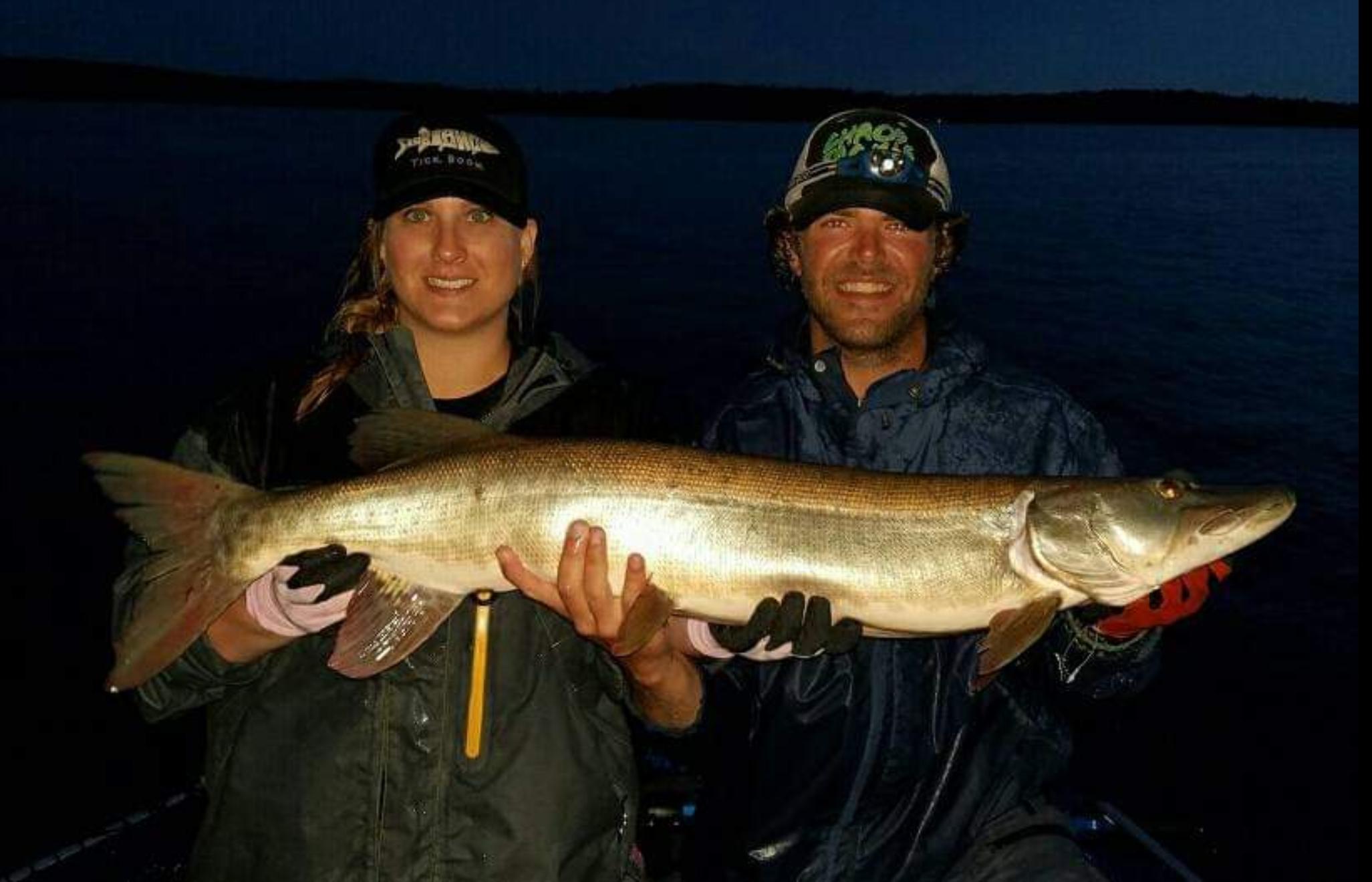 Girl and Guy holding a Lake Vermilion Muskie at night