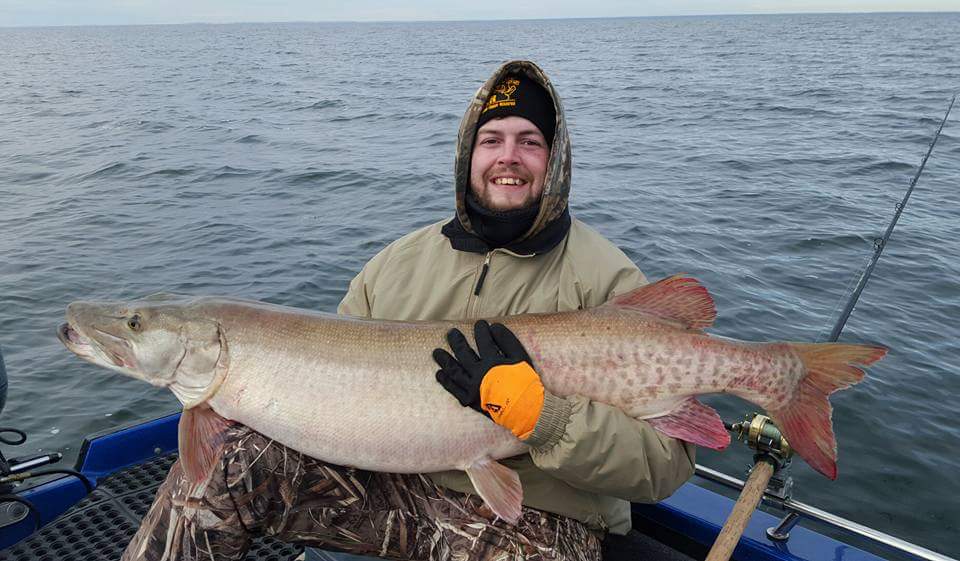 Fishing on Lake Vermilion holding up a trophy size muskie on a cold day on the water
